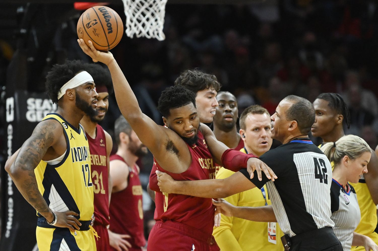 Cleveland Cavaliers guard Donovan Mitchell (45) holds the ball away from referee Eric Lewis (42) after a jump ball was called during the second half against the Indiana Pacers at Rocket Mortgage FieldHouse.